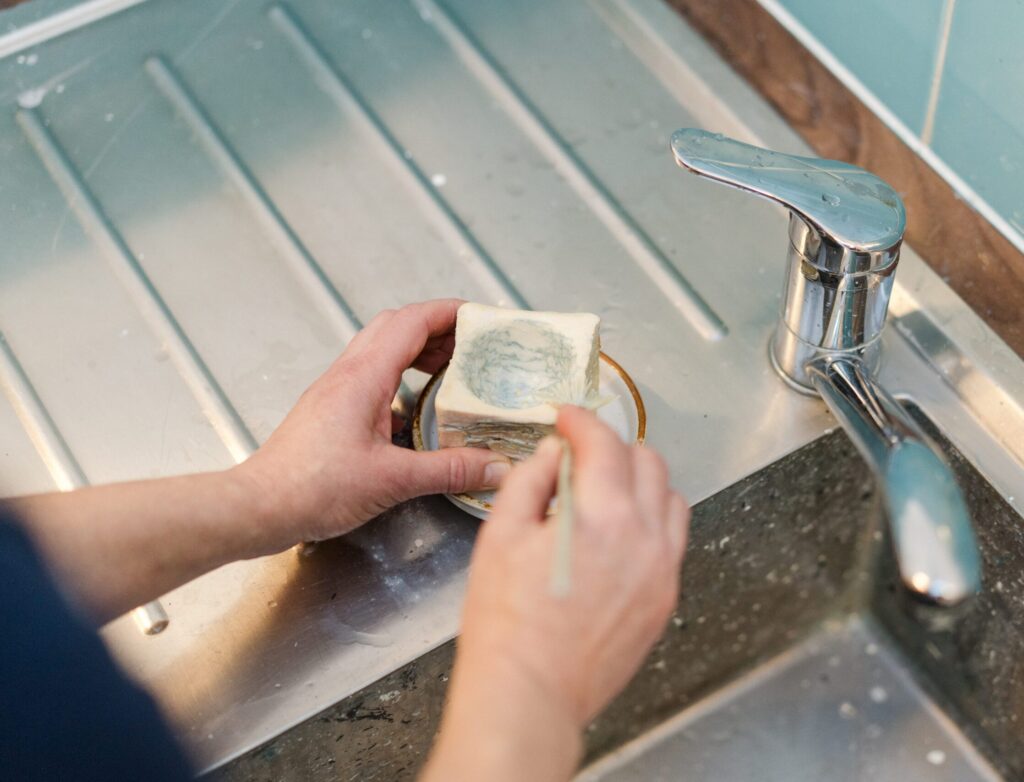 using brush soap to clean a paintbrush