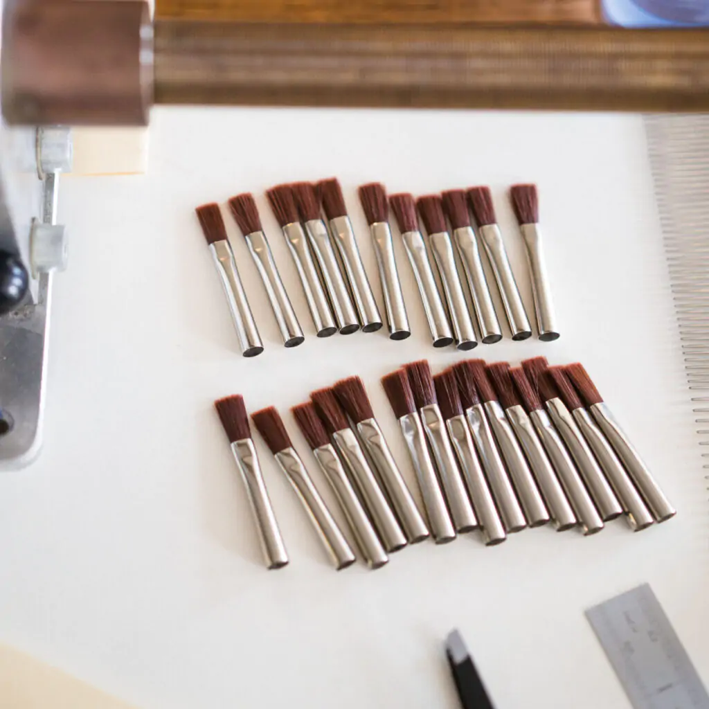 Image of lots of artist paintbrush heads laid side by side on a white background