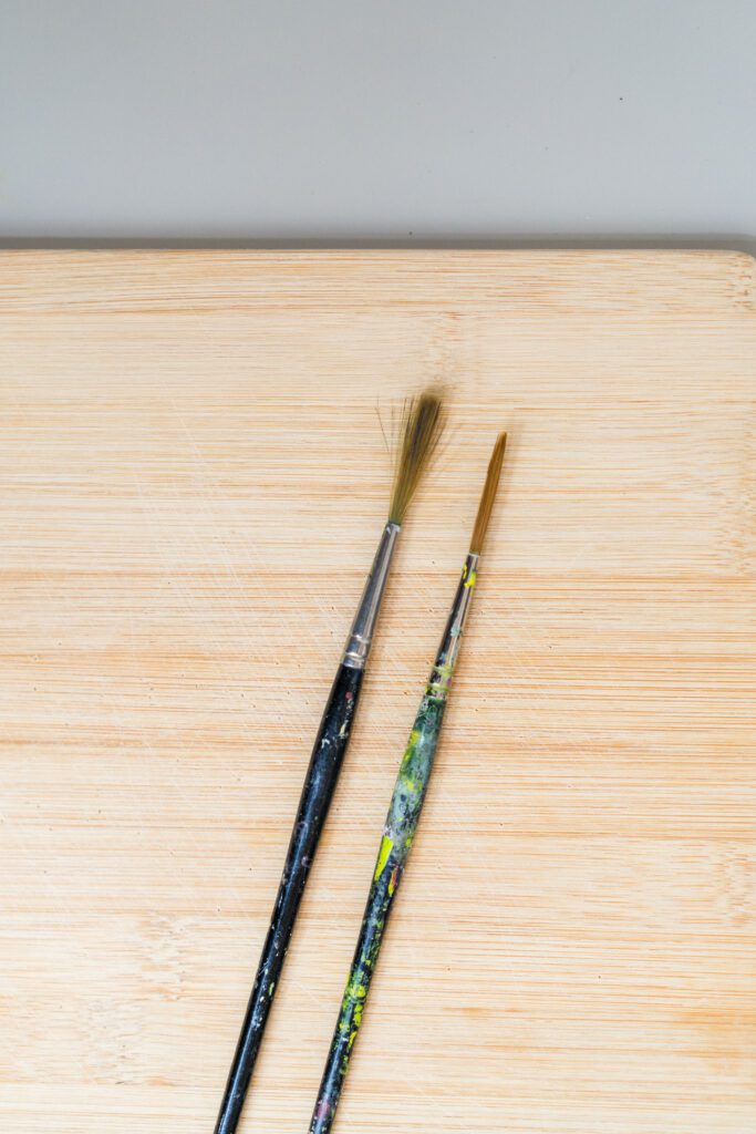 Image shows two paintbrushes side-by-side one frayed and one in great condition