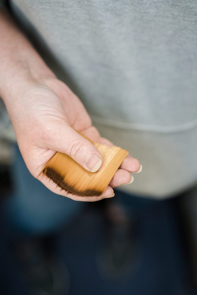 A hand holding loose paintbrush hairs