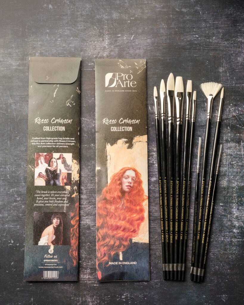 All of the Rosso Crimson x Pro Arte brushes lined up next to their packaging sleeves.