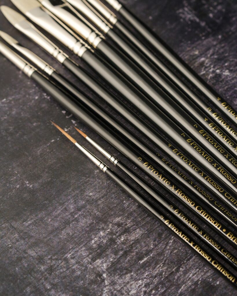 Close up of Rosso Crimson x Pro Arte brushes, focusing on the two smaller synthetic brushes.